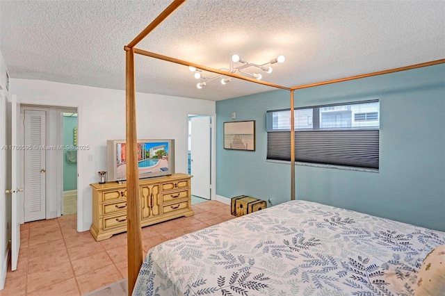 2500 NE 9th St Unit 111, Fort Lauderdale, FL 33304 - bedroom featuring a textured ceiling, baseboards, and light tile patterned floors
