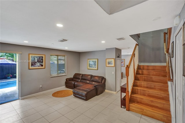 living area with baseboards, stairway, visible vents, and a wealth of natural light