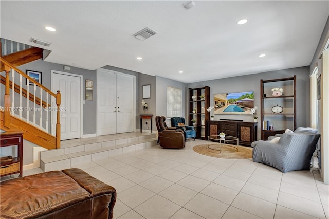 tiled living area featuring visible vents, recessed lighting, and stairs