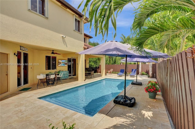 view of swimming pool with a fenced in pool, a fenced backyard, a patio area, a ceiling fan, and outdoor dining space