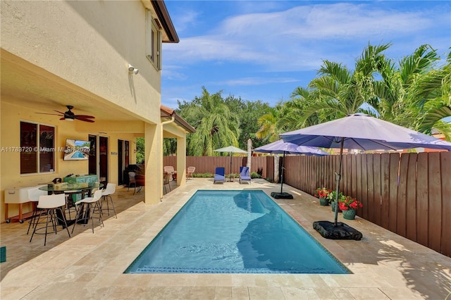 view of swimming pool featuring a fenced in pool, a fenced backyard, outdoor dining space, a patio area, and ceiling fan