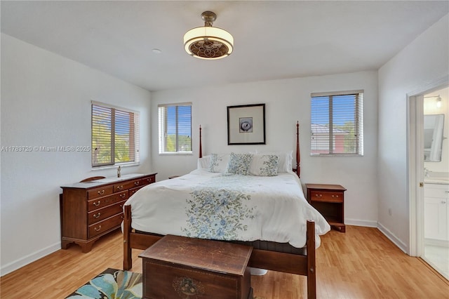 bedroom featuring baseboards, multiple windows, and light wood finished floors