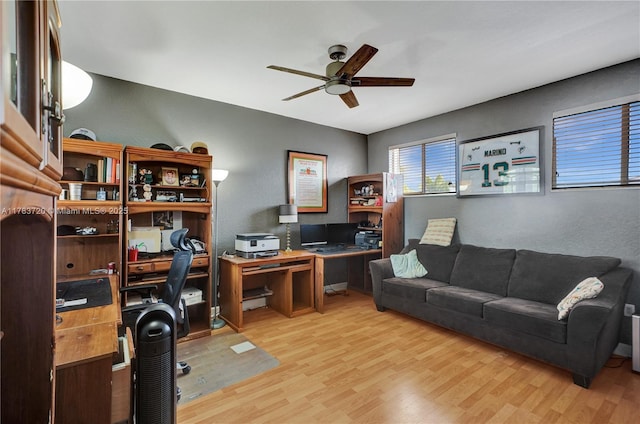 home office with ceiling fan, a textured wall, and wood finished floors