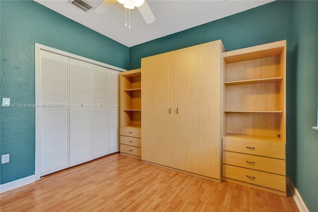 unfurnished bedroom featuring baseboards, visible vents, light wood-style floors, a closet, and ceiling fan
