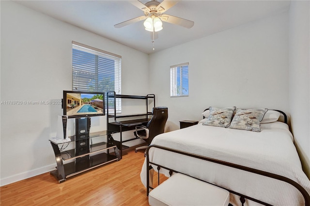 bedroom with light wood-style flooring, baseboards, and ceiling fan
