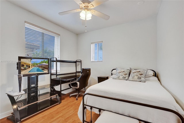 bedroom with wood finished floors, a ceiling fan, and baseboards