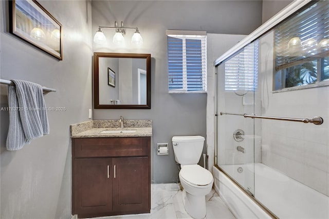 bathroom featuring marble finish floor, vanity, enclosed tub / shower combo, and toilet