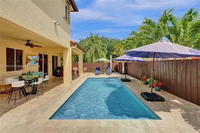 view of swimming pool featuring ceiling fan, a fenced backyard, a fenced in pool, and a patio