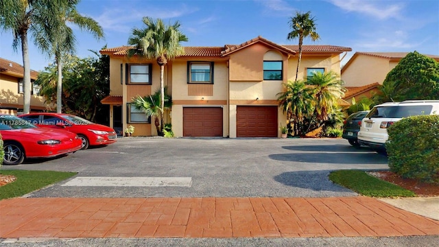 11282 SW 9th Ct, Pembroke Pines, FL 33025 - view of front of property with a tile roof, stucco siding, an attached garage, and asphalt driveway