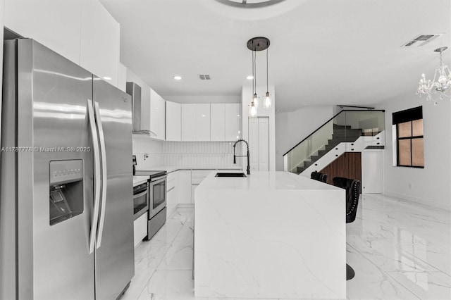 4814 NW 56th Ct, Tamarac, FL 33319 - kitchen with appliances with stainless steel finishes, wall chimney exhaust hood, white cabinets, light marble finish floors, and modern cabinets