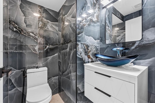4814 NW 56th Ct, Tamarac, FL 33319 - half bathroom with tile walls, marble tiled flooring, vanity, and toilet