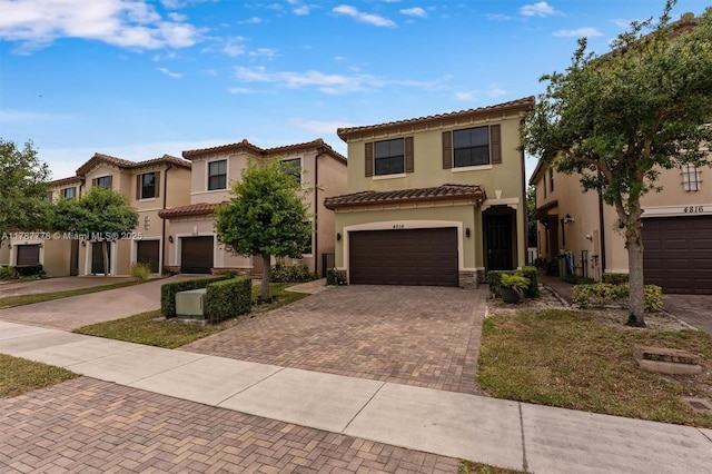 4814 NW 56th Ct, Tamarac, FL 33319 - mediterranean / spanish-style home with decorative driveway, stucco siding, a tile roof, and an attached garage