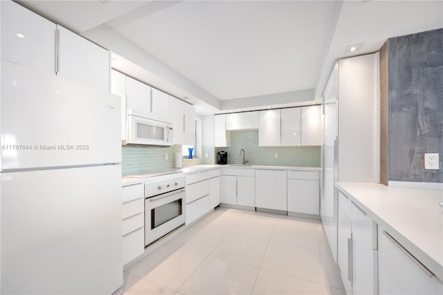 3180 S Ocean Dr Unit 1608, Hallandale Beach, FL 33009 - kitchen with backsplash, a sink, light tile patterned flooring, white appliances, and white cabinetry