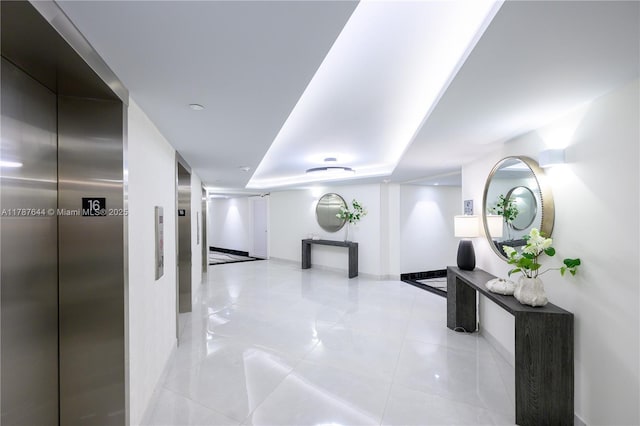 3180 S Ocean Dr Unit 1608, Hallandale Beach, FL 33009 - hallway with baseboards, elevator, light tile patterned floors, and a tray ceiling