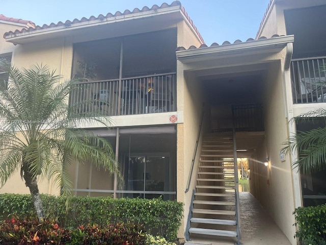 1245 SW 46th Ave Unit 1210, Pompano Beach, FL 33069 - rear view of house with stairway, stucco siding, a tiled roof, and a balcony