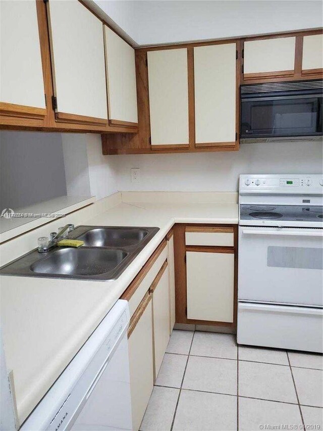1245 SW 46th Ave Unit 1210, Pompano Beach, FL 33069 - kitchen with white appliances, light countertops, a sink, and light tile patterned flooring