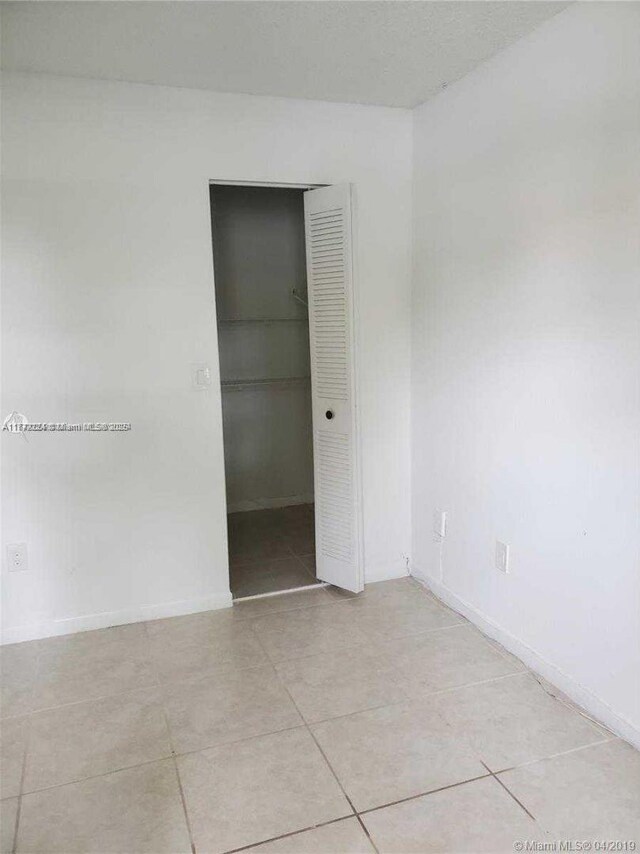 1245 SW 46th Ave Unit 1210, Pompano Beach, FL 33069 - empty room with light tile patterned flooring and baseboards