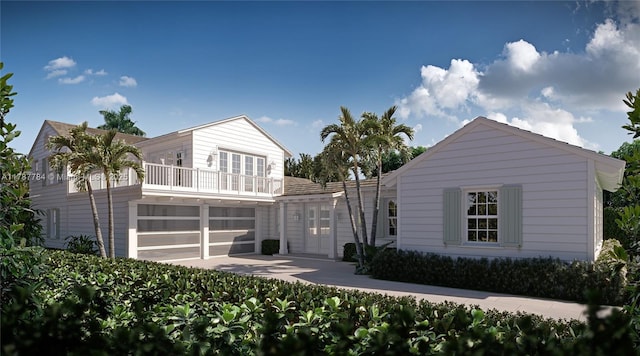 3609 Washington Rd, West Palm Beach, FL 33405 - rear view of house with a balcony, a garage, french doors, and concrete driveway