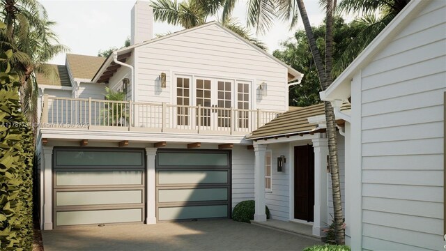3609 Washington Rd, West Palm Beach, FL 33405 - back of house with a balcony, concrete driveway, a chimney, and a garage