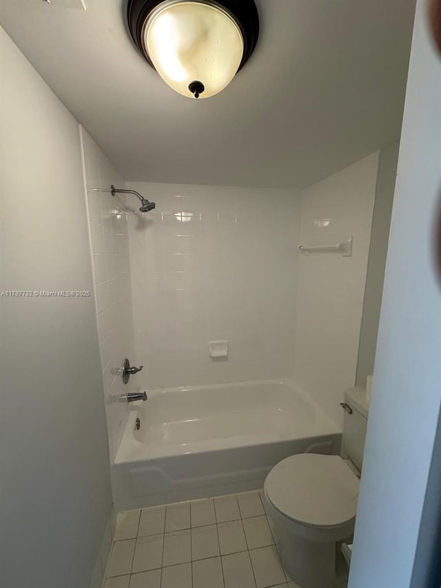 bathroom with tile patterned floors, bathing tub / shower combination, and toilet
