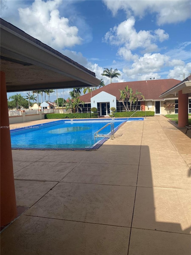 community pool featuring a patio area and fence