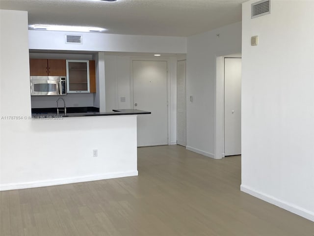 18800 NE 29th Ave Unit 1028, Aventura, FL 33180 - kitchen featuring stainless steel microwave, wood finished floors, and visible vents