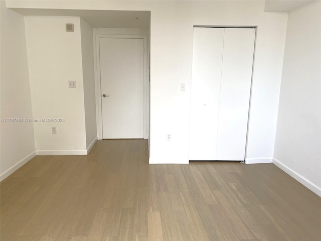 18800 NE 29th Ave Unit 1028, Aventura, FL 33180 - unfurnished bedroom featuring baseboards, wood finished floors, and a closet