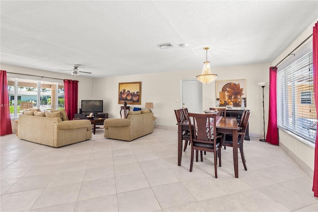dining room featuring a healthy amount of sunlight, a textured ceiling, visible vents, and light tile patterned floors