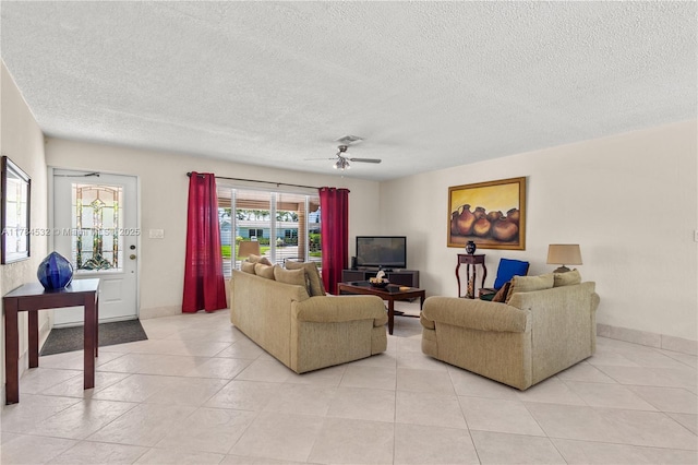 living area featuring a ceiling fan, baseboards, a textured ceiling, and light tile patterned flooring