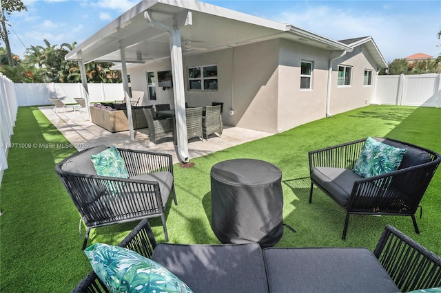 1990 NE 35th St, Lighthouse Point, FL 33064 - back of house featuring a fenced backyard, an outdoor hangout area, stucco siding, a patio, and a lawn