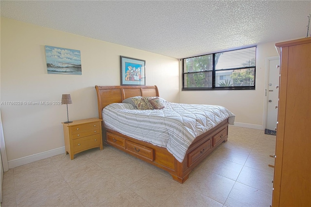 bedroom with baseboards and a textured ceiling