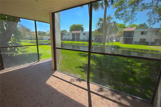 unfurnished sunroom with a water view