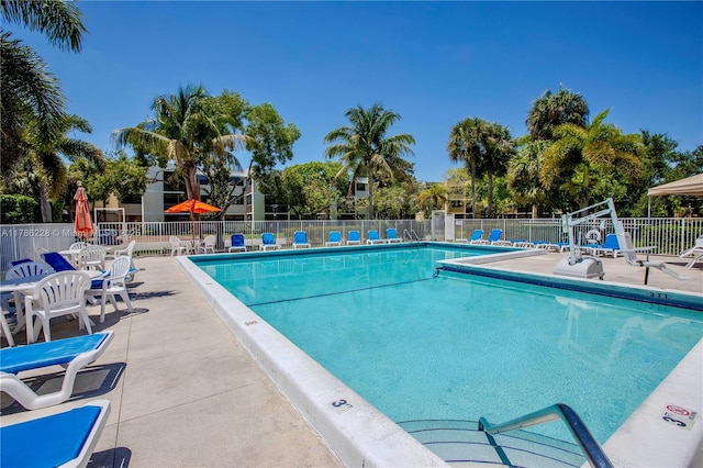 pool with a patio and fence