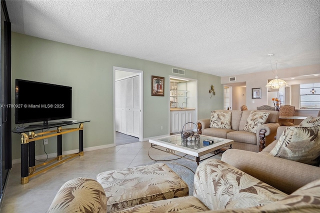 10000 S Ocean Dr Unit 703, Jensen Beach, FL 34957 - living room featuring a textured ceiling, light tile patterned floors, and baseboards