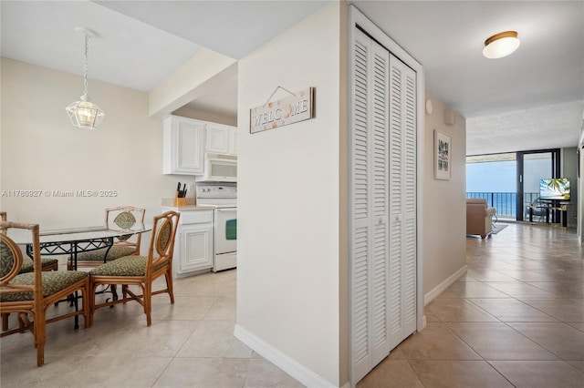 10000 S Ocean Dr Unit 703, Jensen Beach, FL 34957 - kitchen featuring white appliances, light tile patterned flooring, white cabinetry, and light countertops