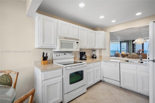 10000 S Ocean Dr Unit 703, Jensen Beach, FL 34957 - kitchen with white appliances, a sink, light countertops, white cabinets, and recessed lighting