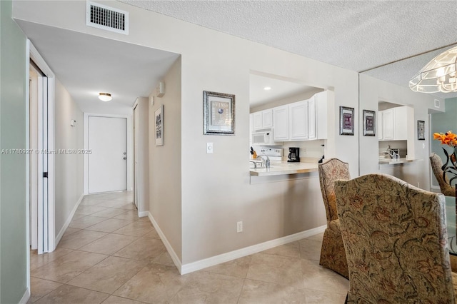10000 S Ocean Dr Unit 703, Jensen Beach, FL 34957 - hall featuring light tile patterned floors, a textured ceiling, and baseboards