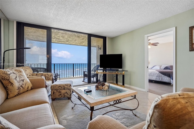 10000 S Ocean Dr Unit 703, Jensen Beach, FL 34957 - living room with floor to ceiling windows, light tile patterned floors, ceiling fan, and a textured ceiling