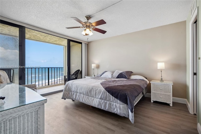 10000 S Ocean Dr Unit 703, Jensen Beach, FL 34957 - bedroom with expansive windows, access to exterior, wood finished floors, baseboards, and a textured ceiling