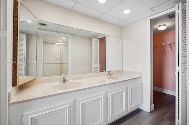 10000 S Ocean Dr Unit 703, Jensen Beach, FL 34957 - full bathroom featuring a paneled ceiling, wood finished floors, a shower stall, baseboards, and double vanity