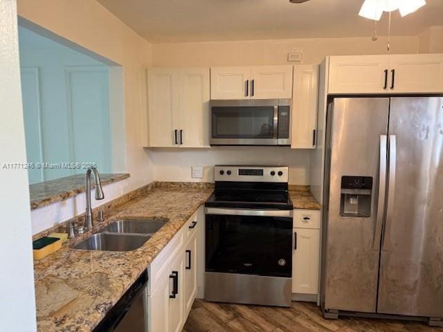 6101 N Falls Circle Dr Unit 312, Lauderhill, FL 33319 - kitchen with stainless steel appliances, white cabinets, wood finished floors, and light stone counters