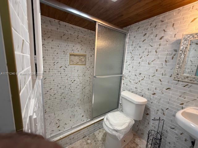 6101 N Falls Circle Dr Unit 312, Lauderhill, FL 33319 - full bathroom featuring wood ceiling, a shower stall, and brick wall