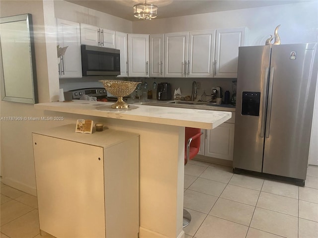 18714 SW 306th Ter, Homestead, FL 33030 - kitchen with stainless steel appliances, a sink, light tile patterned floors, a peninsula, and wood counters