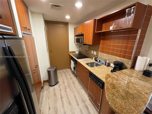 1395 Brickell Ave Unit 3211, Miami, FL 33131 - kitchen featuring a sink, brown cabinetry, black appliances, light wood-style floors, and visible vents