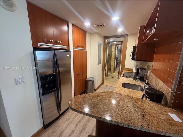1395 Brickell Ave Unit 3211, Miami, FL 33131 - kitchen featuring black appliances, light wood-type flooring, recessed lighting, light stone counters, and electric panel