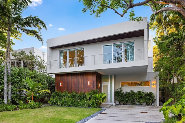 4039 Ventura Ave, Miami, FL 33133 - rear view of house with stucco siding, a lawn, and a balcony