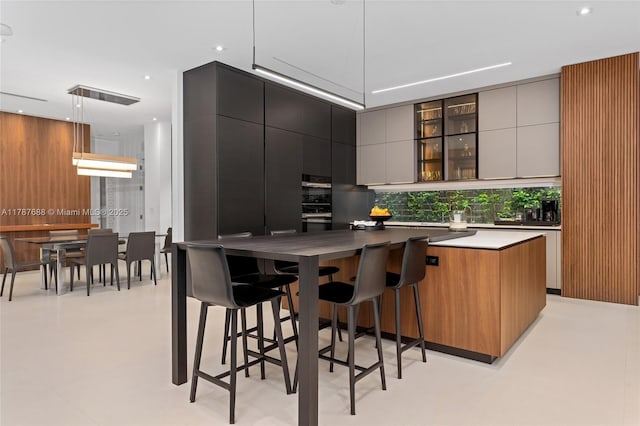4039 Ventura Ave, Miami, FL 33133 - kitchen featuring recessed lighting, a large island, modern cabinets, decorative backsplash, and a breakfast bar area