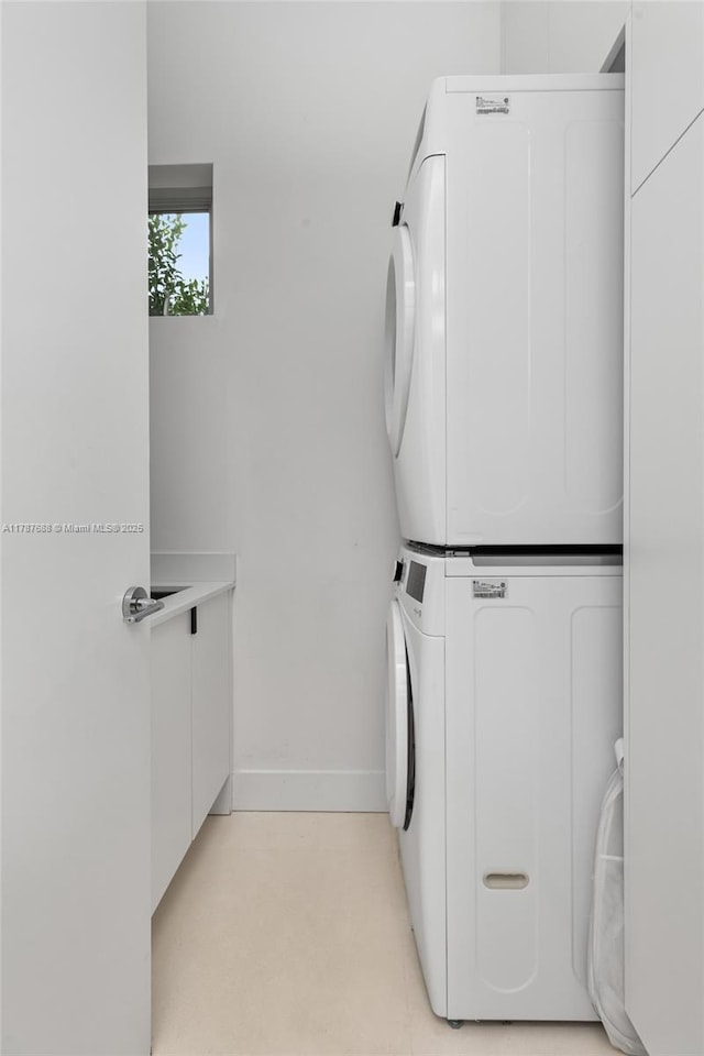4039 Ventura Ave, Miami, FL 33133 - washroom with cabinet space, stacked washer and dryer, and baseboards