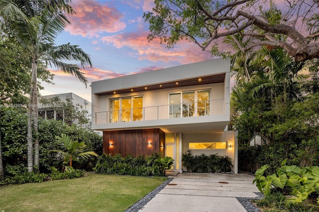 4039 Ventura Ave, Miami, FL 33133 - back of property with stucco siding, driveway, a balcony, and a lawn