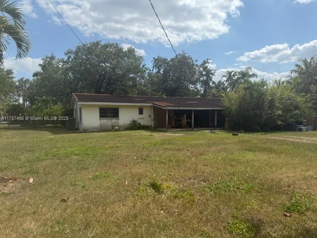 14275 SW 232nd St, Miami, FL 33170 - back of house featuring a yard and an attached carport
